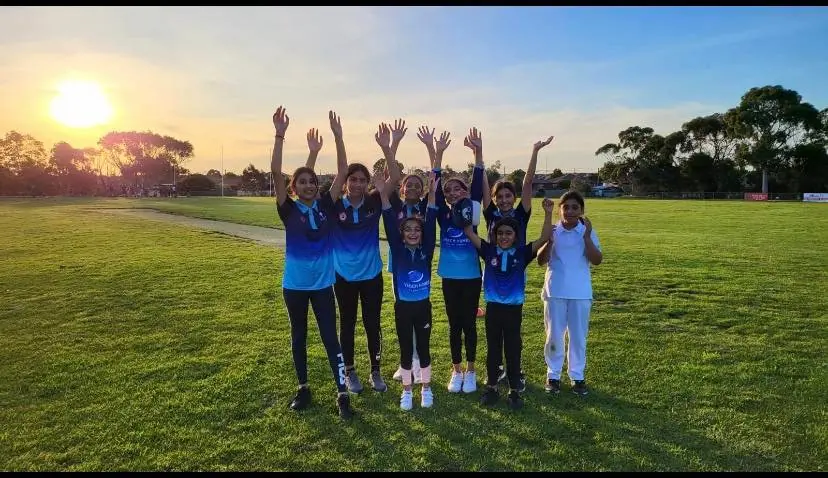Young Chargers jumping for joy at sunset on the oval